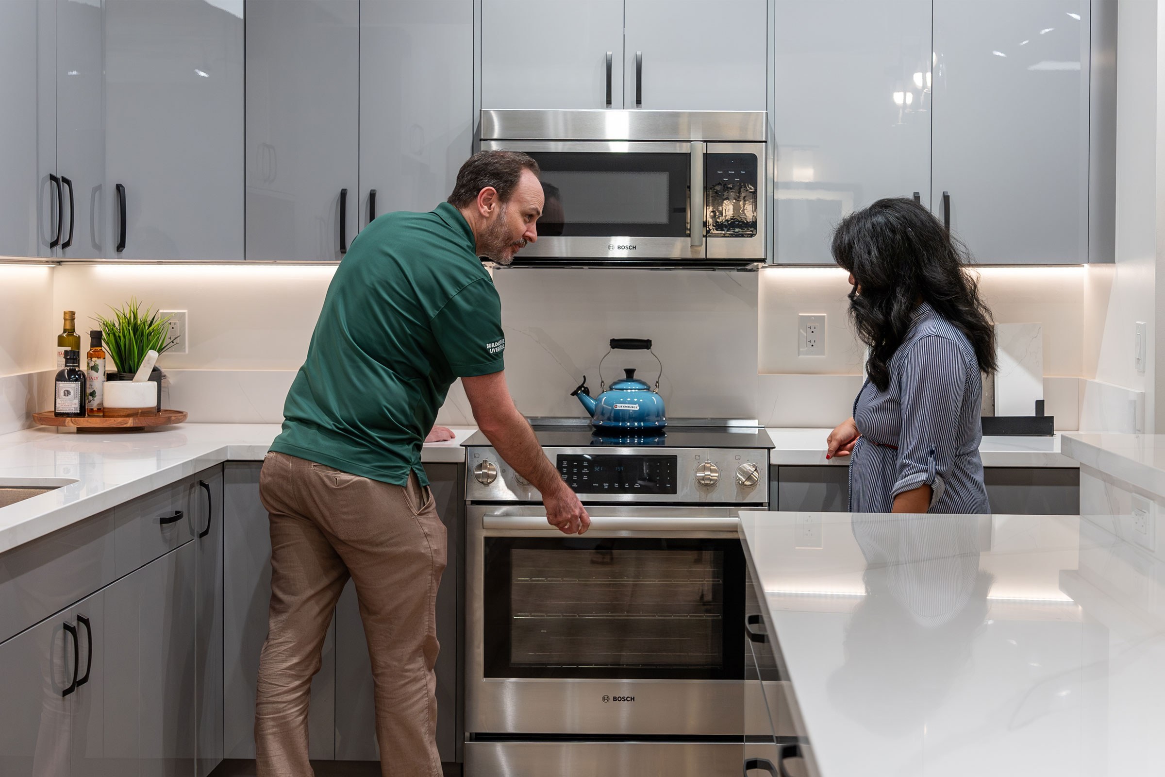 Appliance Specialist shows interested customer the features of the Bosch electric slide in range